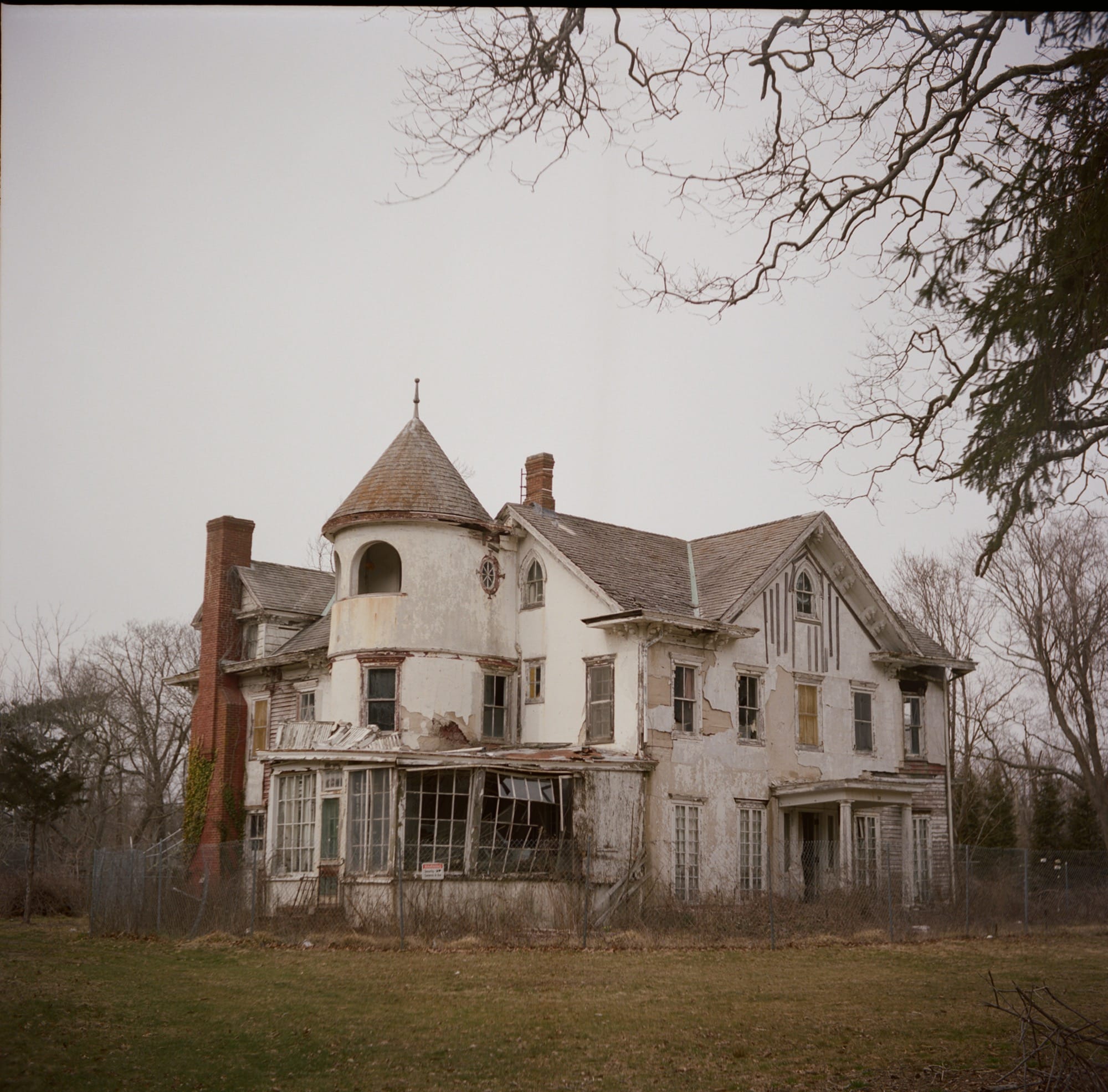 a photo of an abandoned, turreted house by Bryan Sansivero