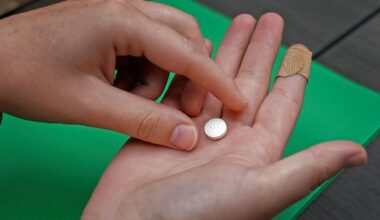 A patient prepares to take the first of two combination pills, mifepristone, for a medication abortion during a visit to a clinic in Kansas City, Kan., on, Oct. 12, 2022. (AP Photo/Charlie Riedel)