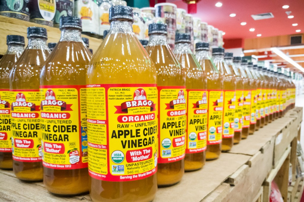 Row of Bragg Organic Apple Cider Vinegar bottles.