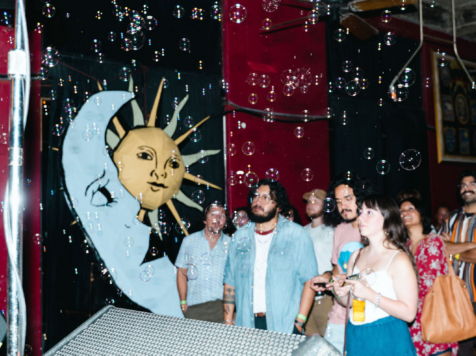 An audience watching the 2024 Solar Flare Music Festival next to a sun and moon decoration.