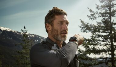 A photo of a man in the mountains wearing a Garmin Fenix 8 Pro, using it to call someone using LTE cellular data.