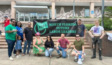 A group of protesters pose in front of a banner that says, "North Florida Future Labor Leaders" at a Labor Day protest.
