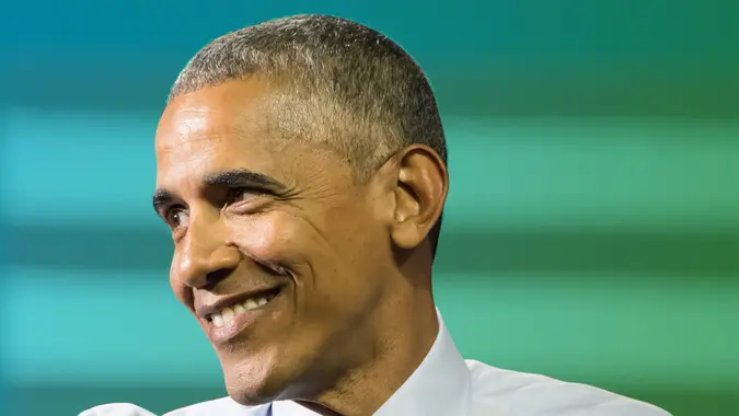 Former president Barack Obama smiling in a shot to illustrate his current wealth and net worth after politics.