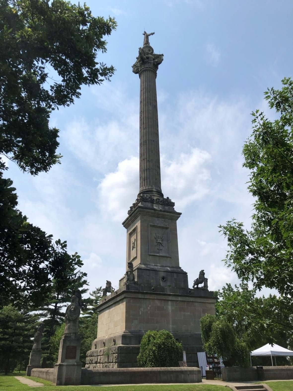 A tall statue featuring a long column and a figure of a man at the very top. 