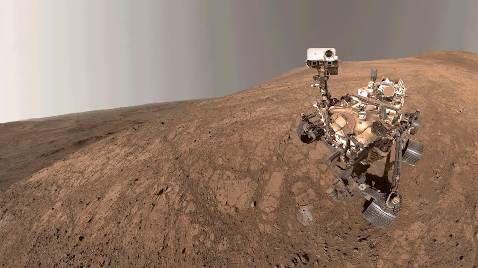  The Perseverance rover on a brownish hill. 