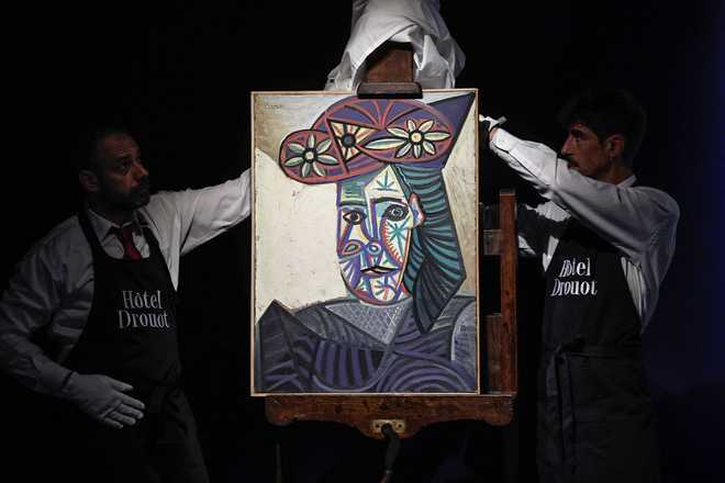 Auction house employees reveal a painting by Spanish artist Pablo Picasso featuring his lover Dora Maar in Paris on Thursday.