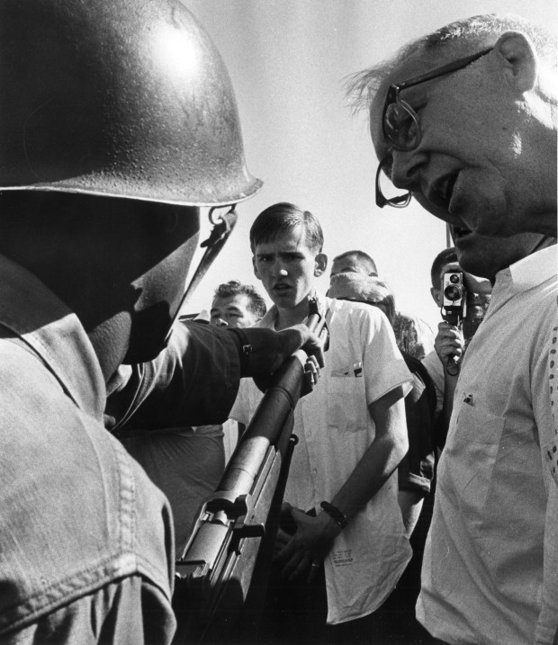 An African American National Guardsman is heckled by men along the route of a civil rights march in September 1966 in Cicero. (Chicago Tribune historical photo)