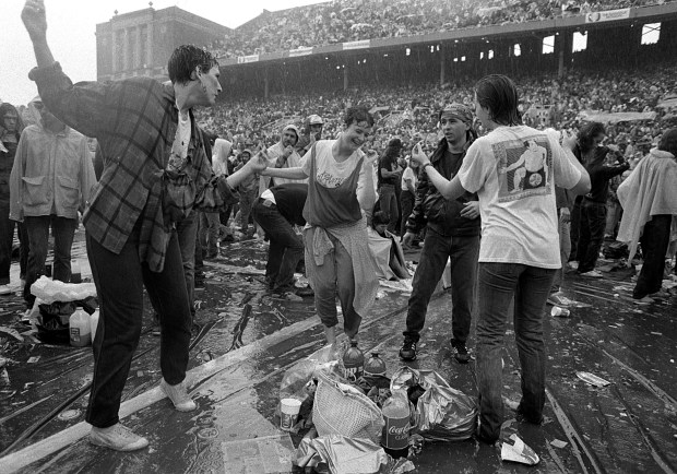Concert goers dance in the rain at the University of Illinois' Memorial Stadium in Champaign during a wet Farm Aid on Sept. 22, 1985. (Ovie Carter/Chicago Tribune) 