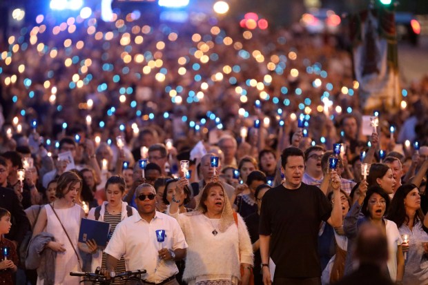 The faithful walk down Chicago Avenue from St. John Cantius Church to the Chicago Water Tower, May 31, 2019. Former Chicago radio host Kevin Matthews had a spiritual awakening after finding a broken statue of the Virgin Mary beside a dumpster and it was the centerpiece of the walk. (Chris Sweda/Chicago Tribune)