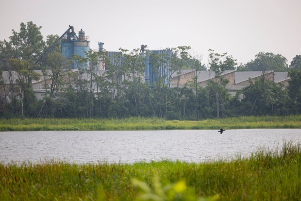 An industrial building sits across from Roxana Marsh, a major restoration site along the Grand Calumet River, on July 31, 2025 in Hammond, Indiana. The Nature Conservancy of Indiana, Indiana Department of Natural Resources Division of Nature Preserves and Illinois-Indiana Sea Grant hosted an educator's workshop on the transformation of polluted industrial landscapes into thriving ecosystems. (Brian Cassella/Chicago Tribune)