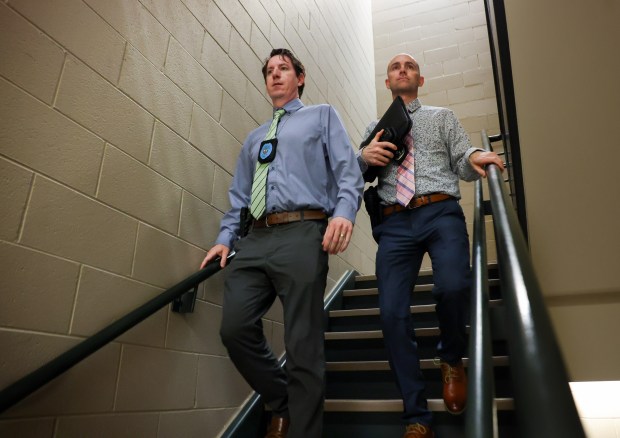 Elgin Detectives Andrew Houghton, left, and Matt Vartanian walk to...