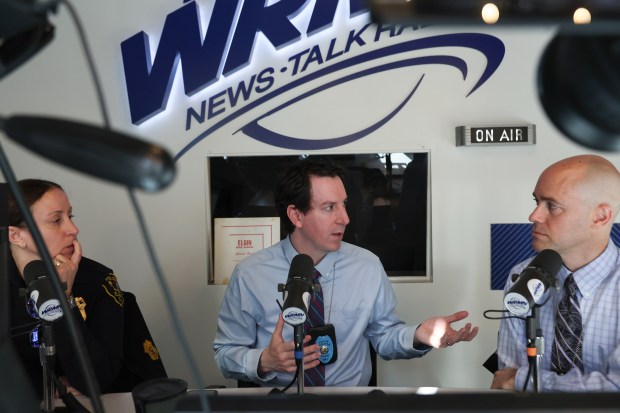 Detective Andrew Houghton, center, talks with Detective Matt Vartanian and...