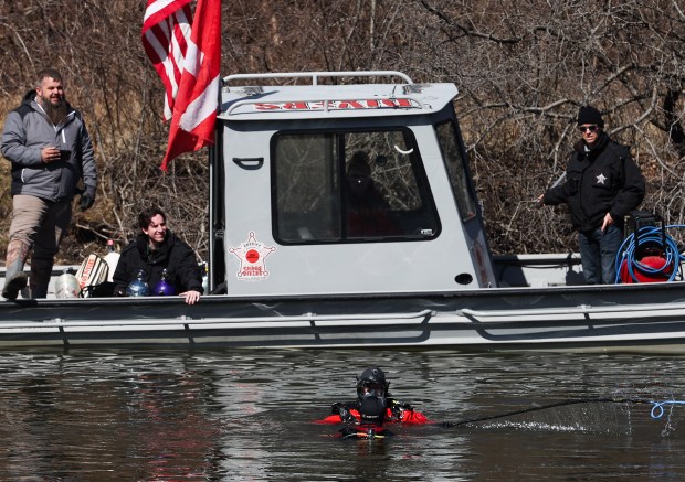 Jacob Grubbs, of Chaos Divers, stands next to Elgin police...