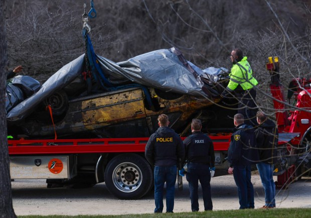 Elgin police and fire officials watch as the Toyota Celica...
