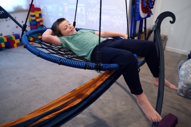 Mollie McGuire's son spends time in his family's basement in Chicago after he returned home from school on Sept. 5, 2025. McGuire said her son is now thriving at his therapeutic day school. (Terrence Antonio James/Chicago Tribune)