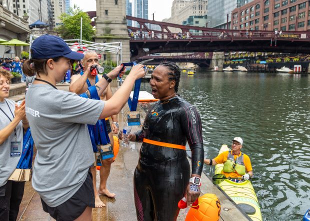 Lovie Twine, 54, of Austin, celebrates while receiving her medal after she completed the Chicago River Swim, on Sept. 21, 2025. Twine explained that she learned to swim at 42-years-old. "I was scared but I'm there now," Twine said. (Dominic Di Palermo/Chicago Tribune)