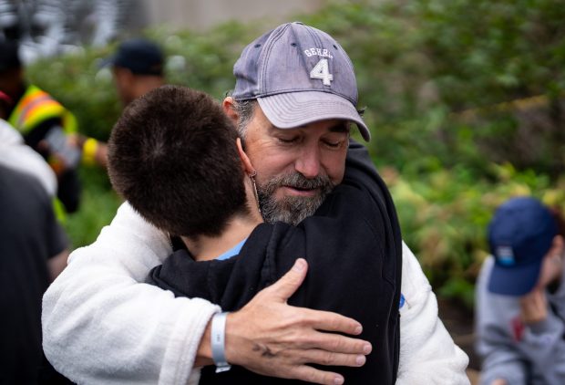 Tim Rooney, of Beverly, hugs his daughter, Colleen Rooney, after finishing the Chicago River Race on Sept. 21, 2025. The race began at the Dearborn Street Bridge and finished at the Clark Street Bridge. (Audrey Richardson/for the Chicago Tribune)