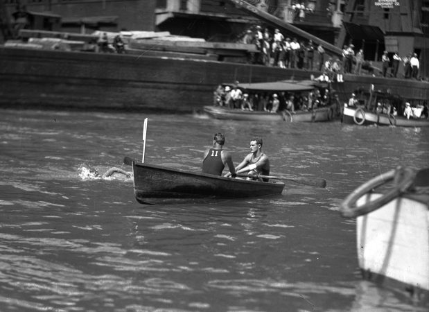 Johnny Weissmuller swims in the river while a Lincoln Park lifeguard, his brother Pete Weissmuller, carefully watches, circa 1926. (Chicago Herald and Examiner)