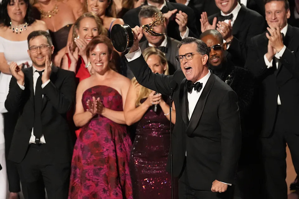 Stephen Colbert holds up his Emmy.