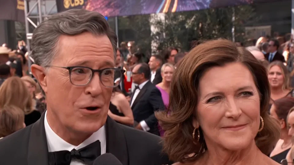Stephen Colbert and wife Emma McGee-Colbert talking on 2025 Emmys red carpet. 