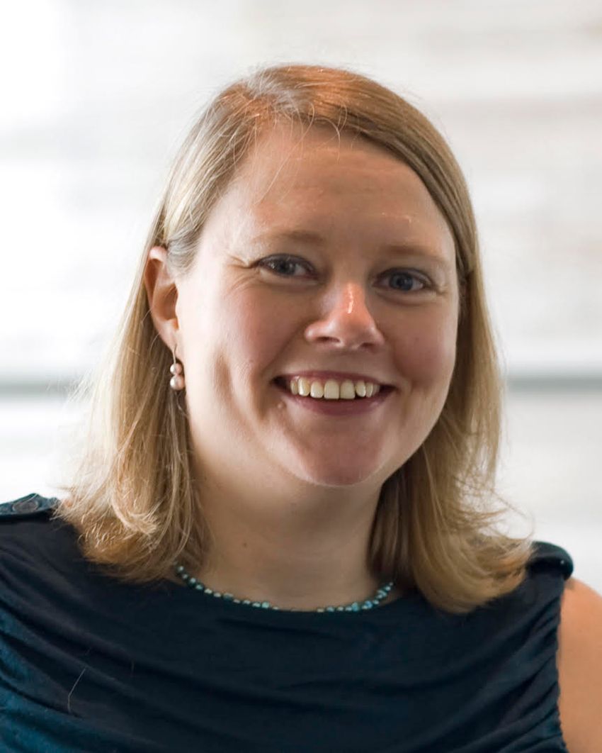 A photograph of Elinor Karlsson, who studies animal genomics, in a black top.
