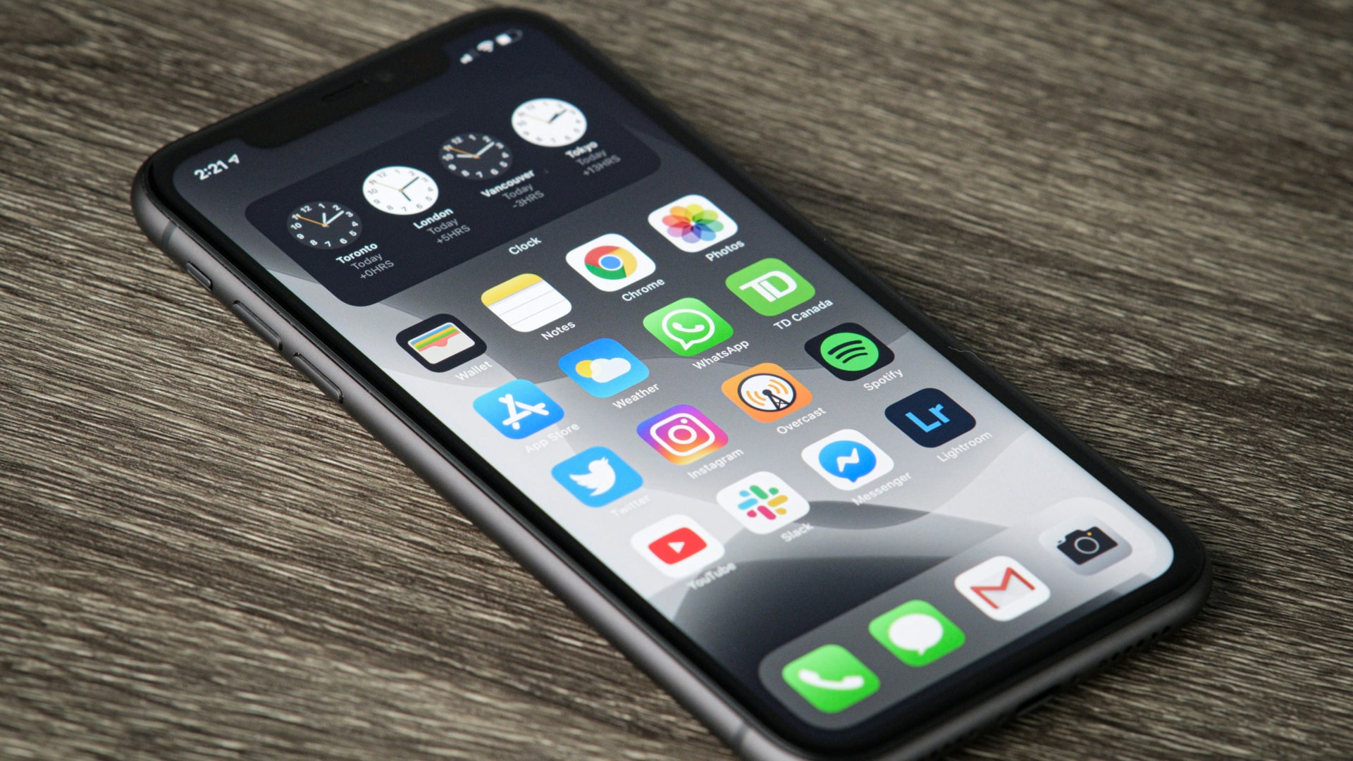 An iPhone 11 on a wooden surface.