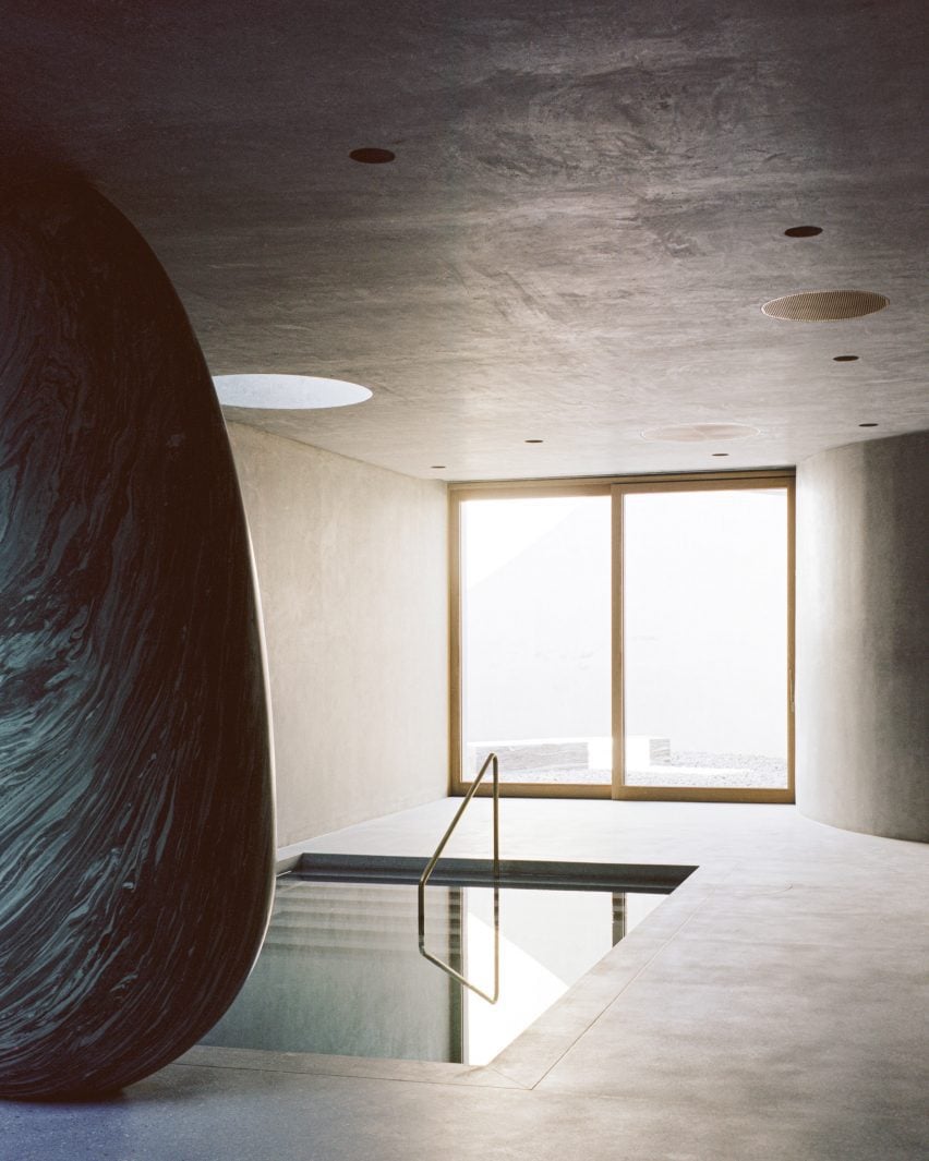 Concrete spa with a sunken pool and a marble ovoid that appears to support the ceiling