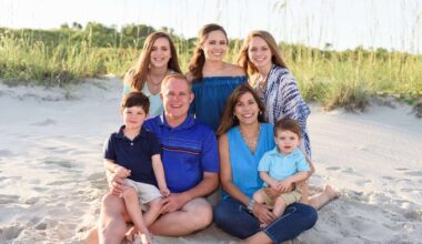 Image of a family sitting and posing for a photo at the beach