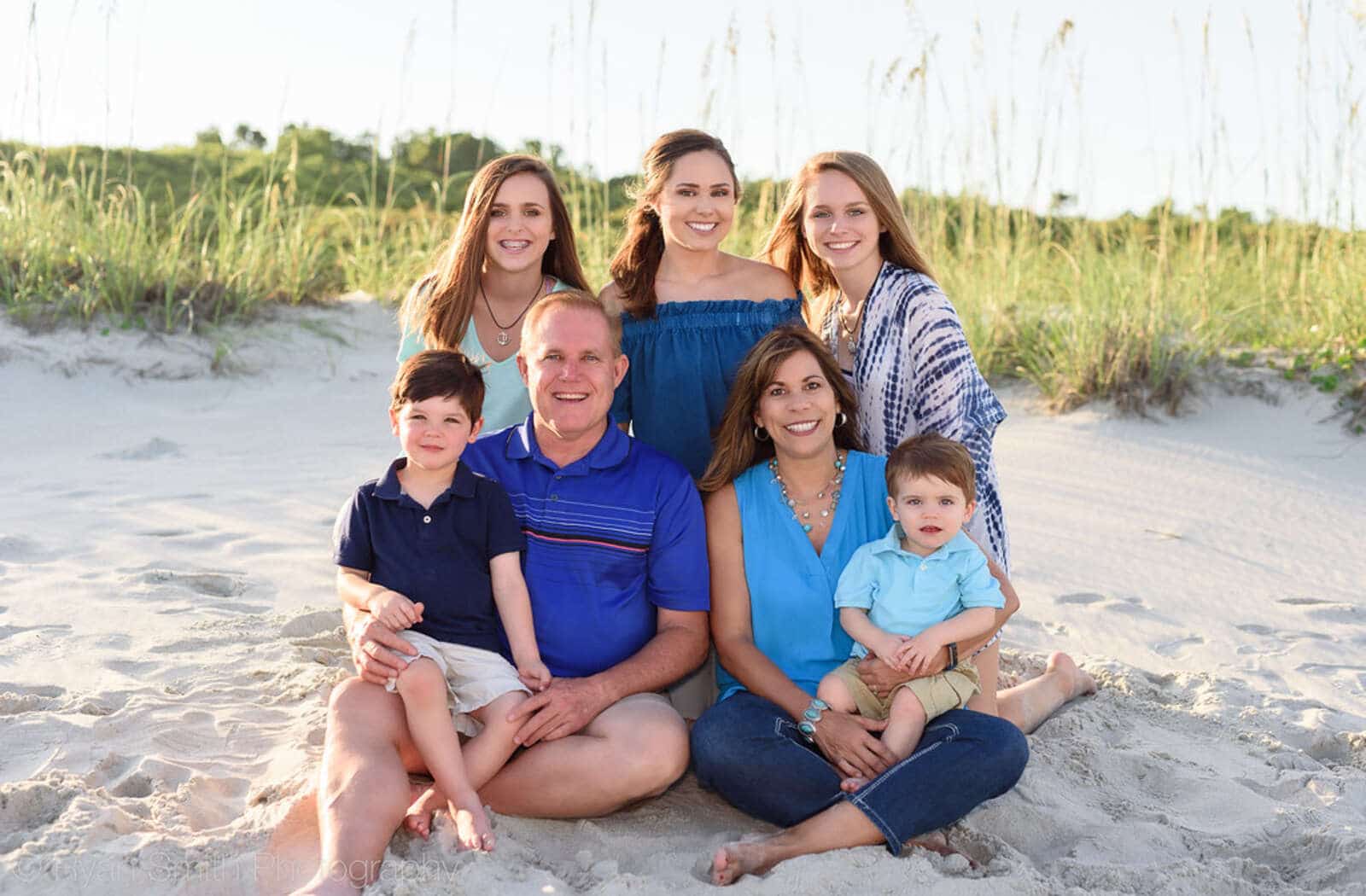 Image of a family sitting and posing for a photo at the beach