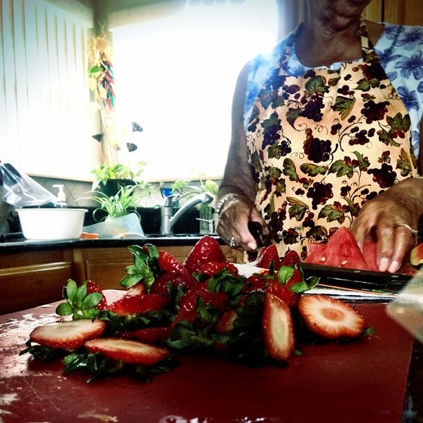 an individual preparing strawberries in a kitchen setting