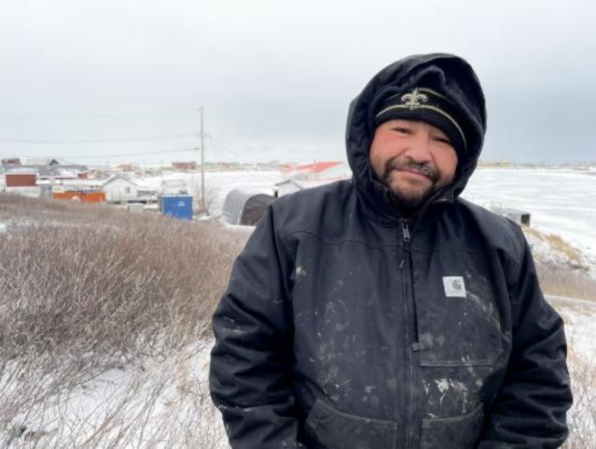 man in coat stands in field