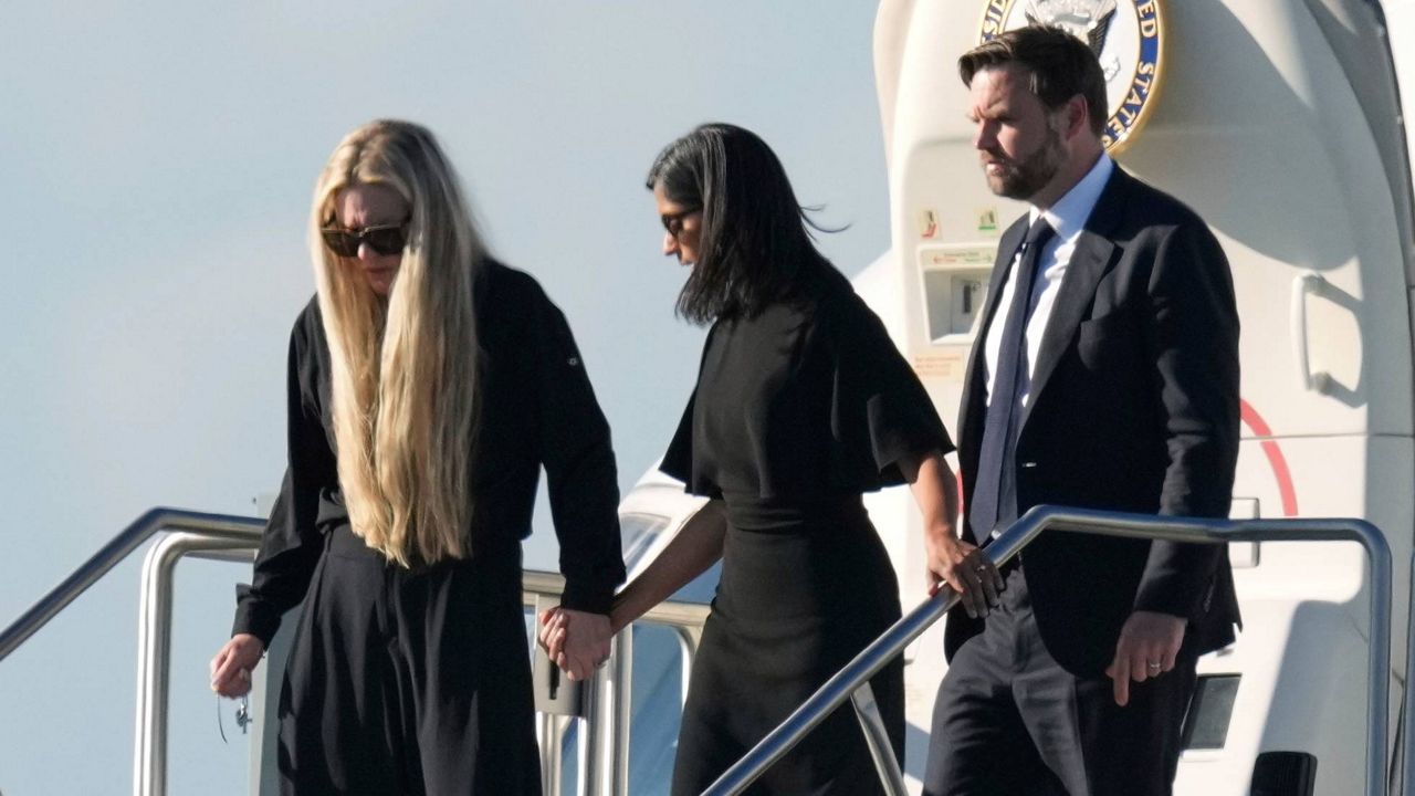 Vice President JD Vance, right, second lady Usha Vance, center, and Erika Kirk, holding a cross on a chain, deplane Air Force Two, carrying the body of Charlie Kirk, Thursday, Sept. 11, 2025, in Phoenix. (AP Photo/Ross D. Franklin)