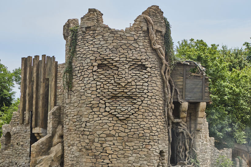 kinetic sculpture outlines moving face onto tower's stonework in french theme park