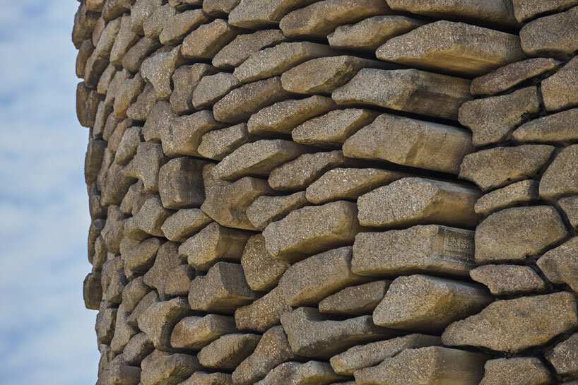 kinetic sculpture outlines moving face onto tower's stonework in french theme park