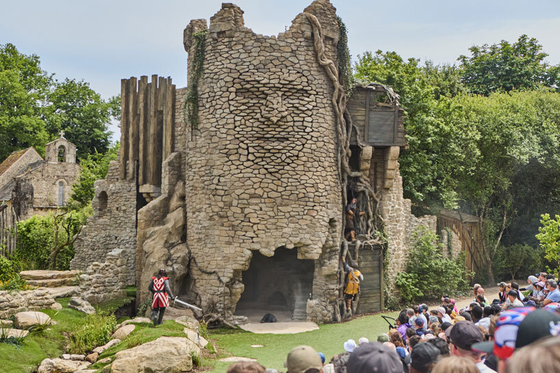 kinetic sculpture outlines moving face onto tower's stonework in french theme park