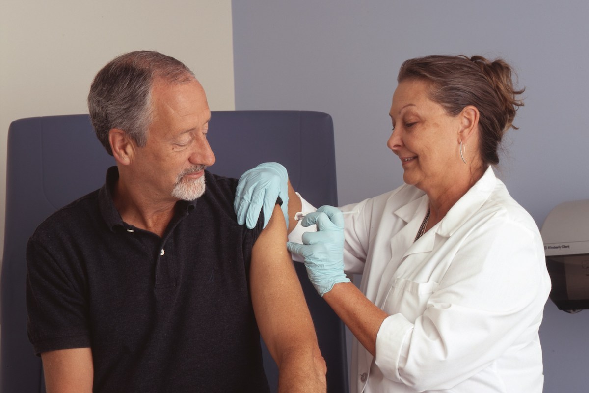 person receiving a vaccine from a health care professional. COVID-19 vaccine featured image