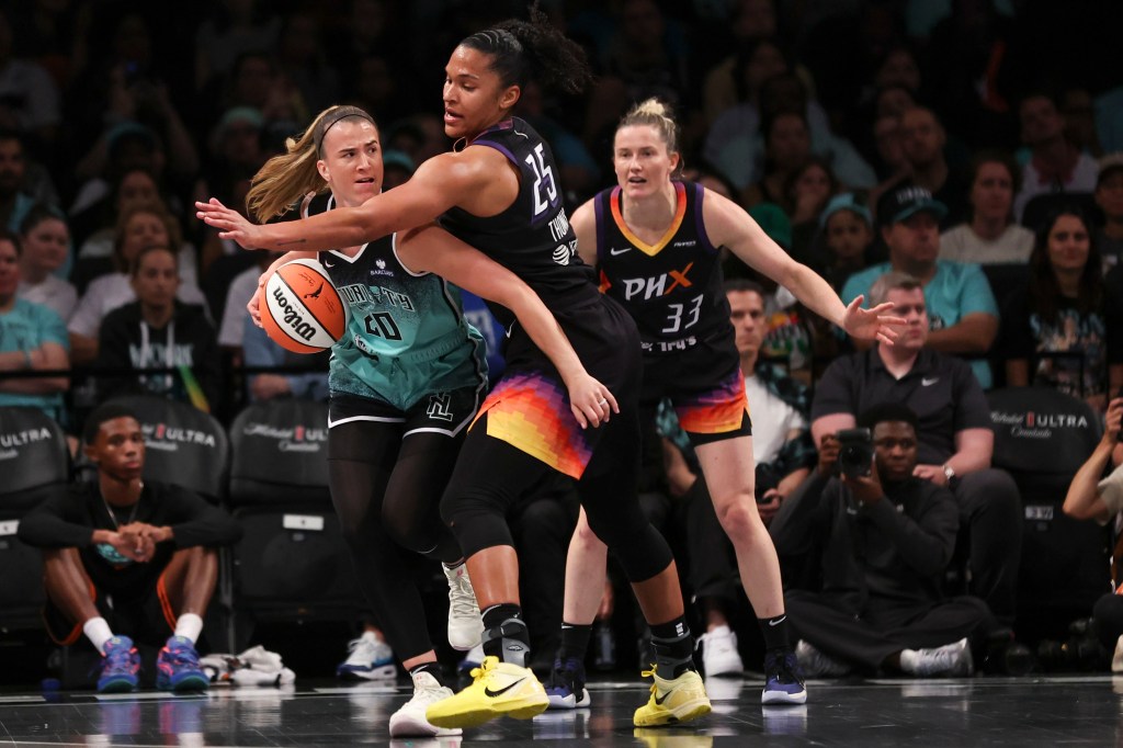 New York Liberty's Sabrina Ionescu (20) defended by Phoenix Mercury's Alyssa Thomas (25) during a basketball game.