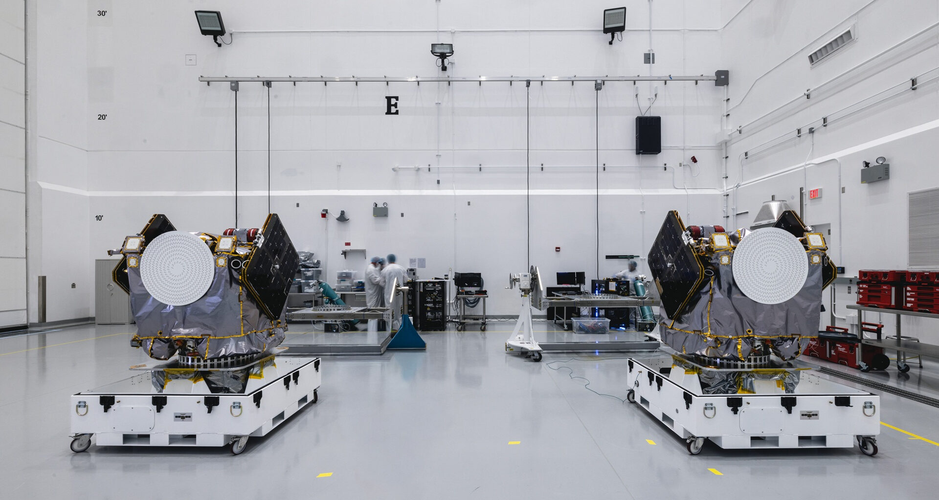Two engines sit on white platforms in a clean warehouse