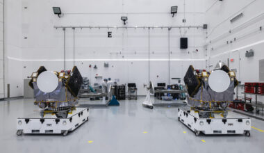 Two engines sit on white platforms in a clean warehouse