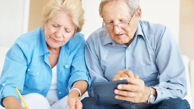 Portrait of a retired senior couple calculating their personal finances at home.
