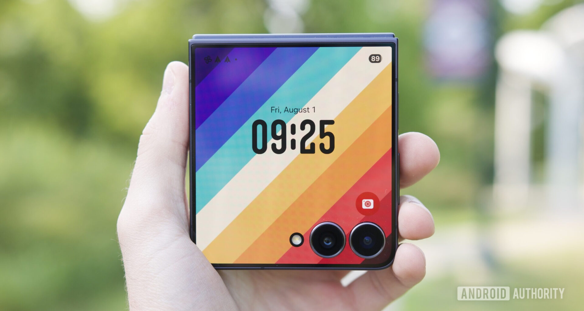 Holding the Galaxy Z Flip 7 with its cover screen on.
