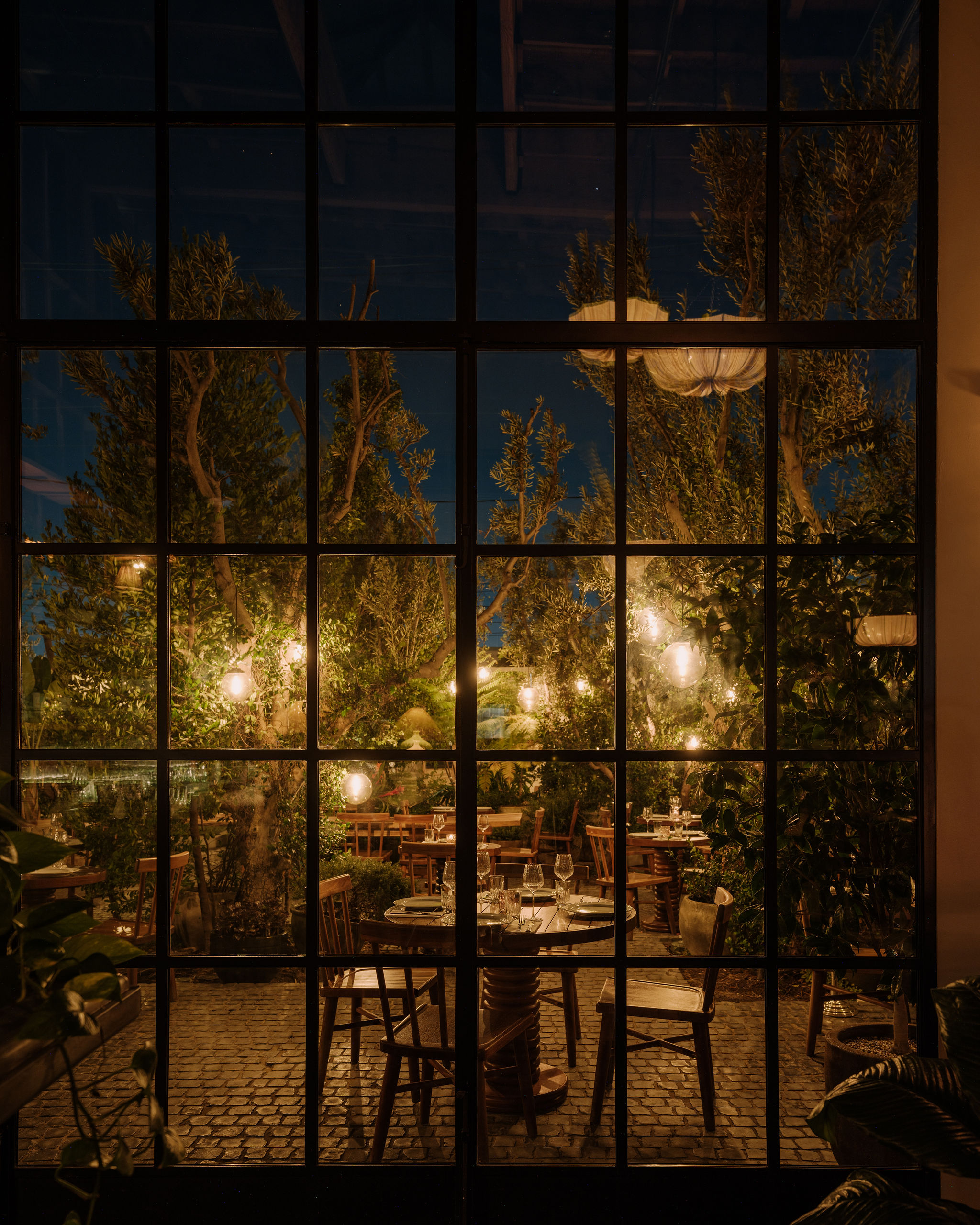 Restaurant patio view from inside through a paneled window.
