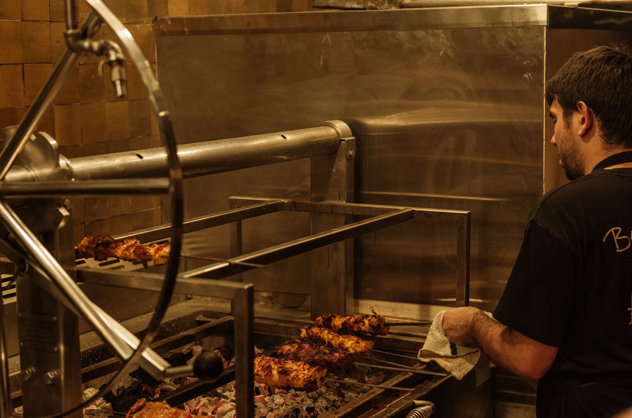 Chef navigating the kebab grill station.