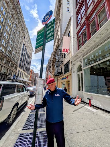 man wearing a blue jacket standing at an express bus stop