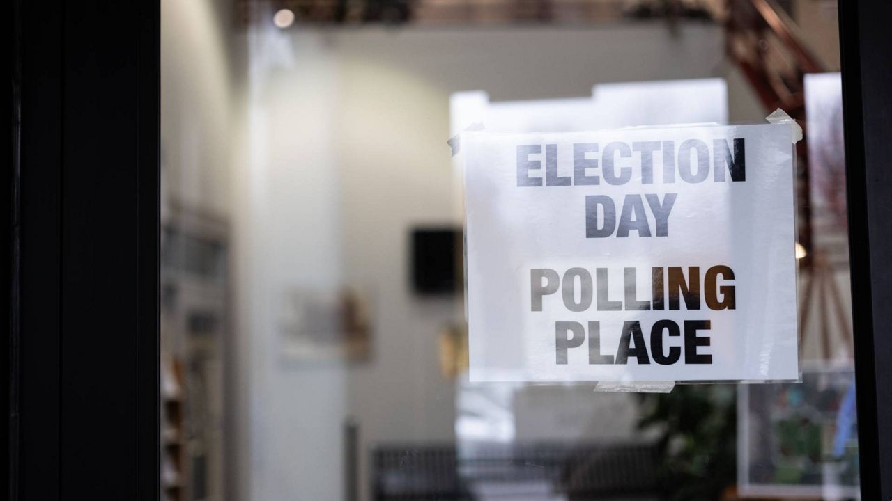 a glass door with a sign taped to it, reading 'election day - polling place'
