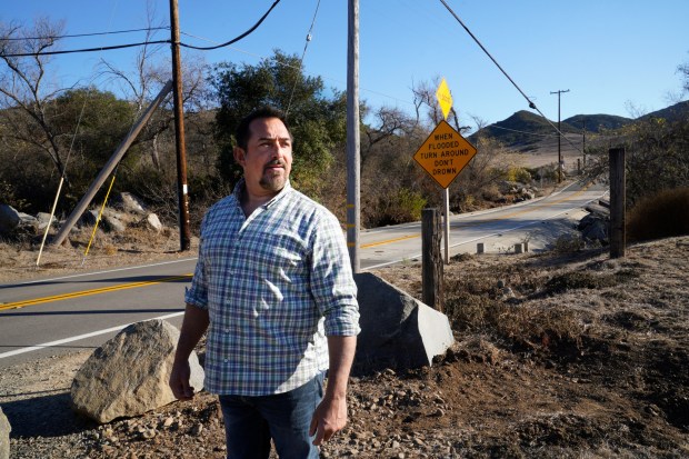JP Theberge stands along the only entry road leading into and exiting from Harmony Grove. (Nelvin C. Cepeda / The San Diego Union-Tribune)