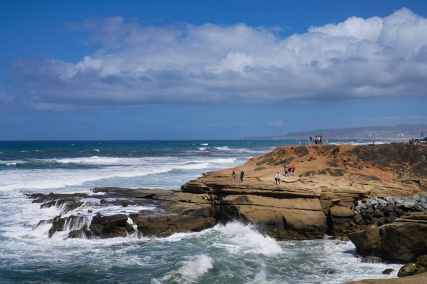 People gather at Sunset Cliffs on a windy Wednesday in April. (Nelvin C. Cepeda / The San Diego Union-Tribune)