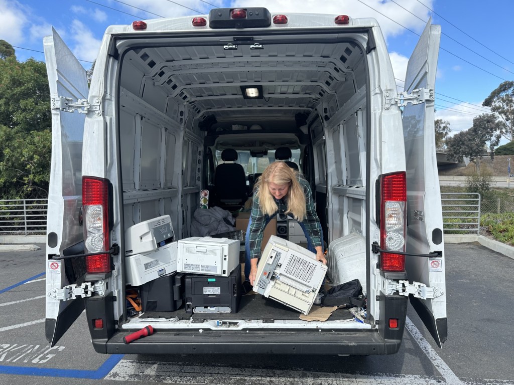 Laura Luxemburg, CEO of the non-profit she started, Ssubi Foundation, loads printers from the county of San Diego into her van on September 10, 2025. / MacKenzie Elmer