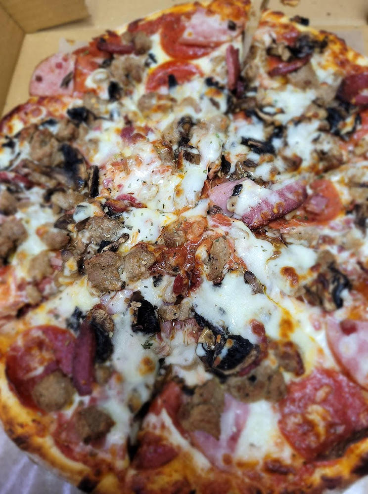A delicious-looking halal pizza with multiple toppings.