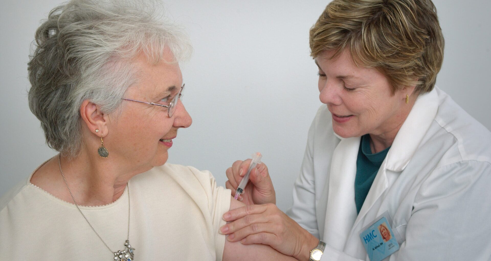 A woman receives a vaccine from a health care professional. RSV vaccine featured img
